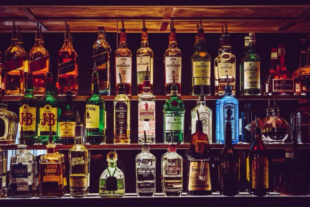A rack of whiskey bottles, blurred behind the main content